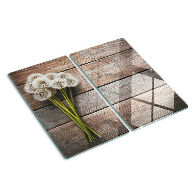 Glasschneidebrett Löwenzahnblüten auf einem hölzernen Hintergrund