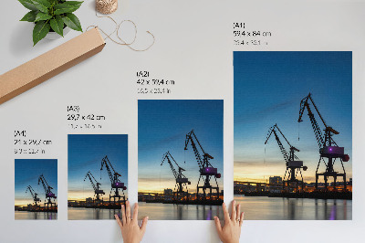 Wandposter Kräne vor der Kulisse eines dynamischen Sonnenuntergangs
