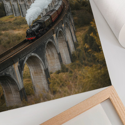 Kunstdruck leinwand Ein Zug auf einer Brücke inmitten grüner Hügel