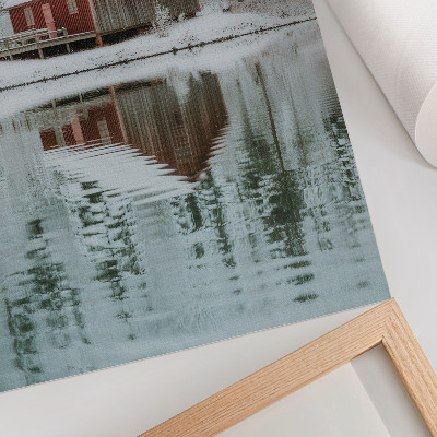 Poster Ein rotes Häuschen zwischen schneebedeckten Bäumen am Wasser