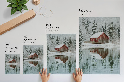 Poster Ein rotes Häuschen zwischen schneebedeckten Bäumen am Wasser