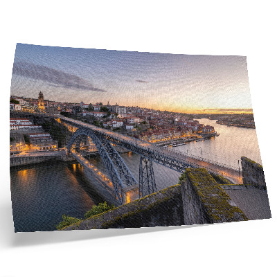 Poster Die Brücke vor dem Hintergrund der untergehenden Sonne und der Stadt