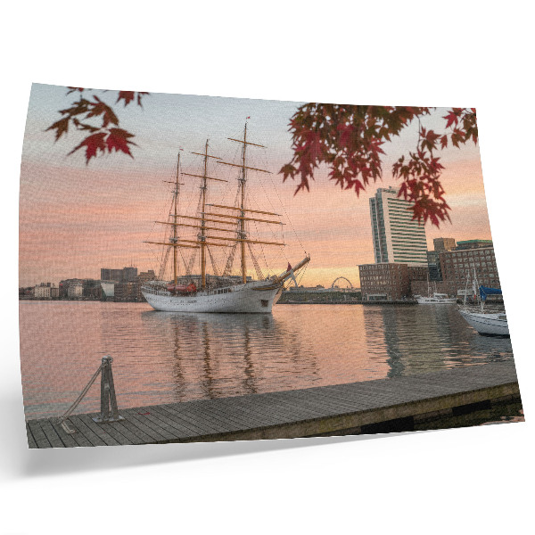 Poster Ein Segelschiff im Sonnenuntergang, ein friedliches Panorama der Stadt