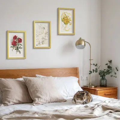 Bilderwand mit roten Rosen, einer weißen Figur und gelben Blumen in einer Vase