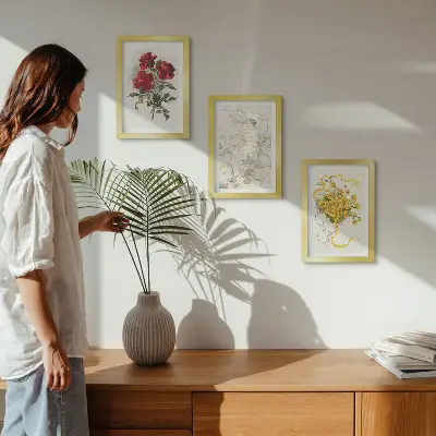 Bilderwand mit roten Rosen, einer weißen Figur und gelben Blumen in einer Vase