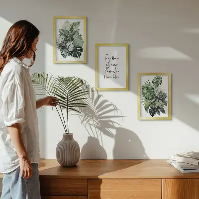Bilderwand mit Motiv von grünen Tropenblättern und dekorativem Schriftzug