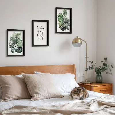 Bilderwand mit Motiv von grünen Tropenblättern und dekorativem Schriftzug