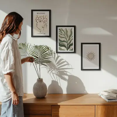 Bilderwand mit abstrakten Pflanzenmustern und Linien in gedeckten Farben